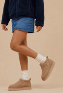Look de inverno feminino com bota de camurça areia e calça jeans — Upper The Label